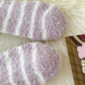 Close up detail view of soft purple and white striped fuzzy coral fleece warm winter socks.