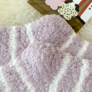 Close-up of cozy purple white striped coral fleece socks, soft fluffy winter sleep socks detail.