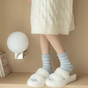 Close-up detail of women's thick plush striped fuzzy socks paired with warm fluffy slippers.