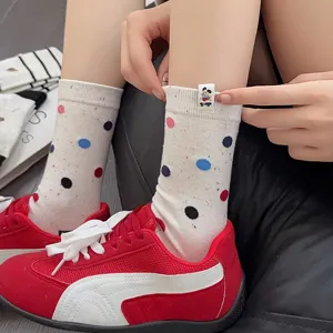 Close-up detail of cute dotted mid-calf socks featuring a playful puppy tag and colorful spots.