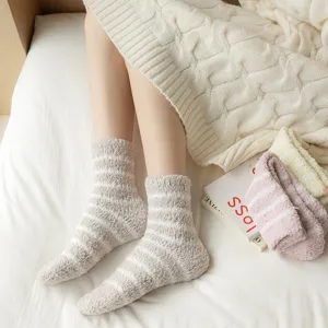 Cozy fluffy striped sleep socks detail, thick coral fleece winter warm socks close up shot.