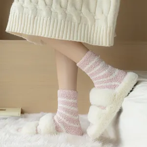 Detail view of women cozy striped fuzzy socks and fluffy slippers, soft coral fleece for warm wear.