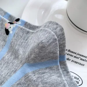 Closeup view of blue-gray striped knit socks featuring cute cartoon puppy embroidery detail.