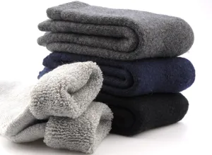 Gros plan de chaussettes en laine épaisse de diverses couleurs à doublure bouclée.