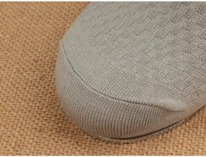 Gros plan détaillé de la tige de chaussure en tricot gris au design texturé respirant.