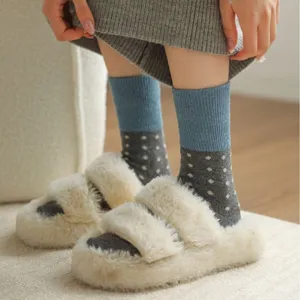 Cozy women's polka dot color block mid-tube socks paired with fluffy plush home slippers.