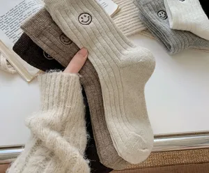 Cozy thick knit winter crew socks with cute embroidered smiley face design for women.