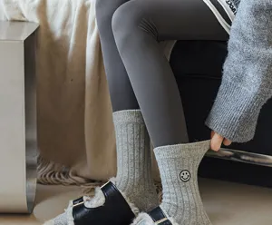 Detailed shot of cozy grey ribbed winter socks featuring cute embroidered smiley face.