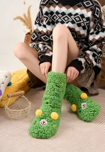 Cozy green fleece floor socks detail showing cute cartoon embroidery and soft thick texture.