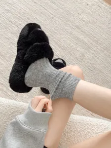 Close-up detail shot of cozy grey ribbed wool knit stacked socks worn indoors.