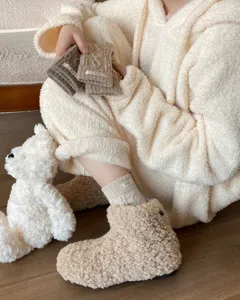 Thick cable knit wool slouch socks with cozy fleece boots, warm winter lifestyle detail shot.