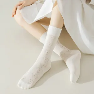 Close-up detail of women's white hollow heart pattern cotton mid-calf socks.
