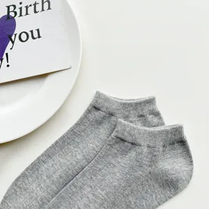 Close-up detail of grey women's low-cut ankle socks, soft knit fabric texture display.