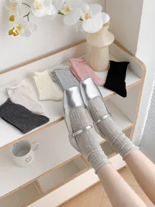 Calzini estivi sottili da donna con risvolto arrotolato abbinati a scarpe in pelle.