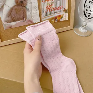 Detail view of women's pink polka dot mesh mid tube socks with cute rolled cuffs for summer.