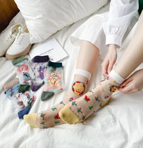 Detailansicht von transparenten Damen Socken aus feiner Seide mit bunten Blumenstickereien.
