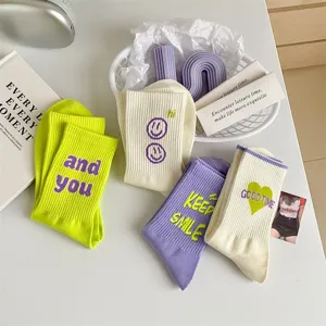 Colorful mid-calf socks with cute embroidery letters and smile patterns, aesthetic style.