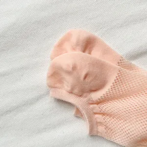 Close up of cute peach pink mesh women low cut boat socks, breathable spring summer style detail.