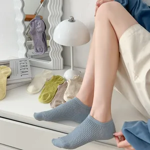 Detail view of breathable mesh low-cut women socks in various candy colors on table scene.
