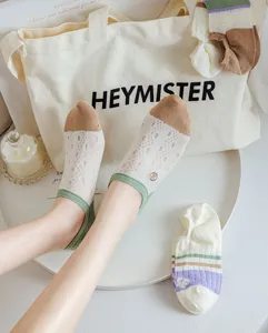 Detail shot of women's low-cut boat socks featuring contrast toe, ribbed cuffs, and soft dot mesh.
