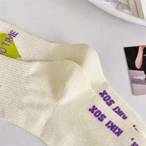 Close-up detail of preppy style women mid-calf socks with letter print and soft dot yarn fabric.