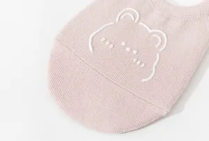 Detailopname van schattige roze damesfootie sok met wit beerachtig patroon motief.