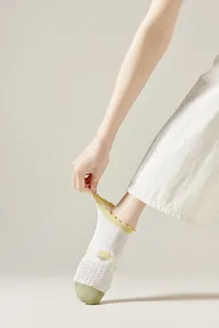 Women breathable mesh short socks with cute yellow tulip embroidery and ruffled cuff design.