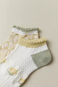 Detail view of women's short socks with cute floral pattern ruffle cuffs and breathable mesh.