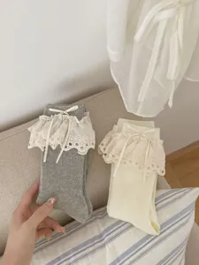 Gros plan détaillé de chaussettes mi-hautes de style JK japonais avec volants et rubans.