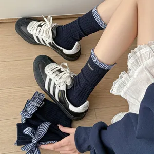 Detailed close-up view of dark blue ribbed socks featuring cute plaid ruffle cuffs and bows.