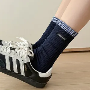 Women's navy blue ribbed crew socks with plaid ruffled trim and cute mini cloth label style.