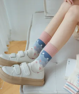Detail shot of cute pink and blue mid-calf socks featuring creative mountain and heart patterns.