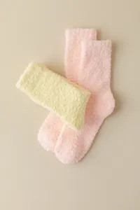 Detailed view of cozy pink and yellow fuzzy coral fleece socks, warm and soft for sleeping.