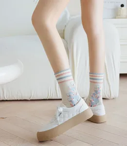 Detail shot of women's cute mid-calf socks with tulip floral embroidery and stripe cuffs.