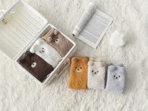 Dettaglio calzini di peluche orsetto, morbido pile corallo, calde calze invernali.