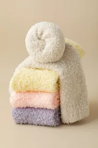 Soft fuzzy coral fleece sleep socks in candy pastel colors, warm thick winter detail view.