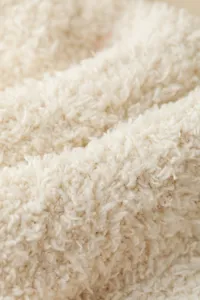 Soft coral fleece fabric close-up detail, thick warm texture for cozy sleep socks.