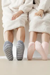 Calzini antiscivolo in morbido pile corallo con gommini per coppie durante l'inverno freddo.