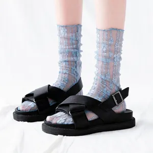 Detailed close up view of blue sheer floral mesh lace socks paired with casual sandals.