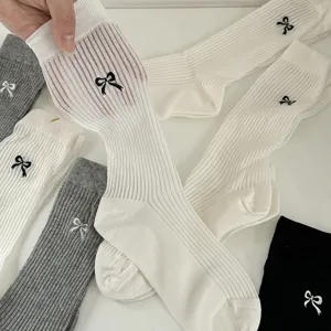 Ribbed knit slouch socks with sweet bow embroidery detail, soft cotton blend for daily wear.