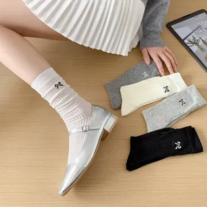Detailed view of women's bow embroidered slouch socks with breathable mesh and ribbed design.