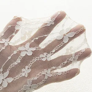 Detail of white floral lace sheer socks, lightweight breathable mesh for women summer wear.