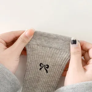 Grey ribbed knit ruffle socks detail featuring cute black bow embroidery, stretchy.