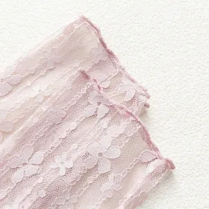Close-up detail of women pink floral lace mesh slouch socks, breathable fabric texture.