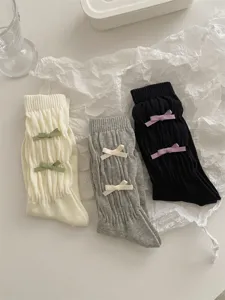 Vue détaillée de chaussettes longues style collège japonais avec joli nœud et texture plissée.