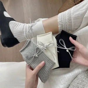 Women knit slouch socks with cute silver bow and heart charm, perfect sweet style detail shot.
