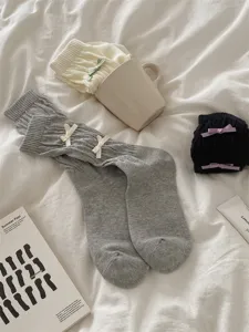 Gros plan de chaussettes longues en tricot douillet avec de jolis petits nœuds, tissu doux.