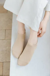 Close-up detail of women's low-cut invisible boat socks in neutral beige, spring summer wear.