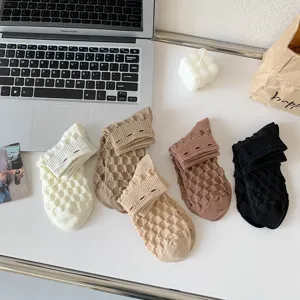 Detailed close-up view of women's bubble knit short socks in assorted colors on a desk.