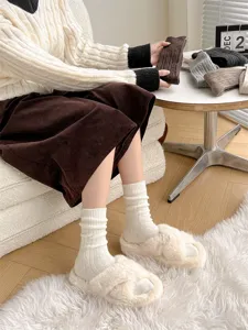 Cozy knit thermal socks and fuzzy plush slippers detail in warm indoor lifestyle setting.